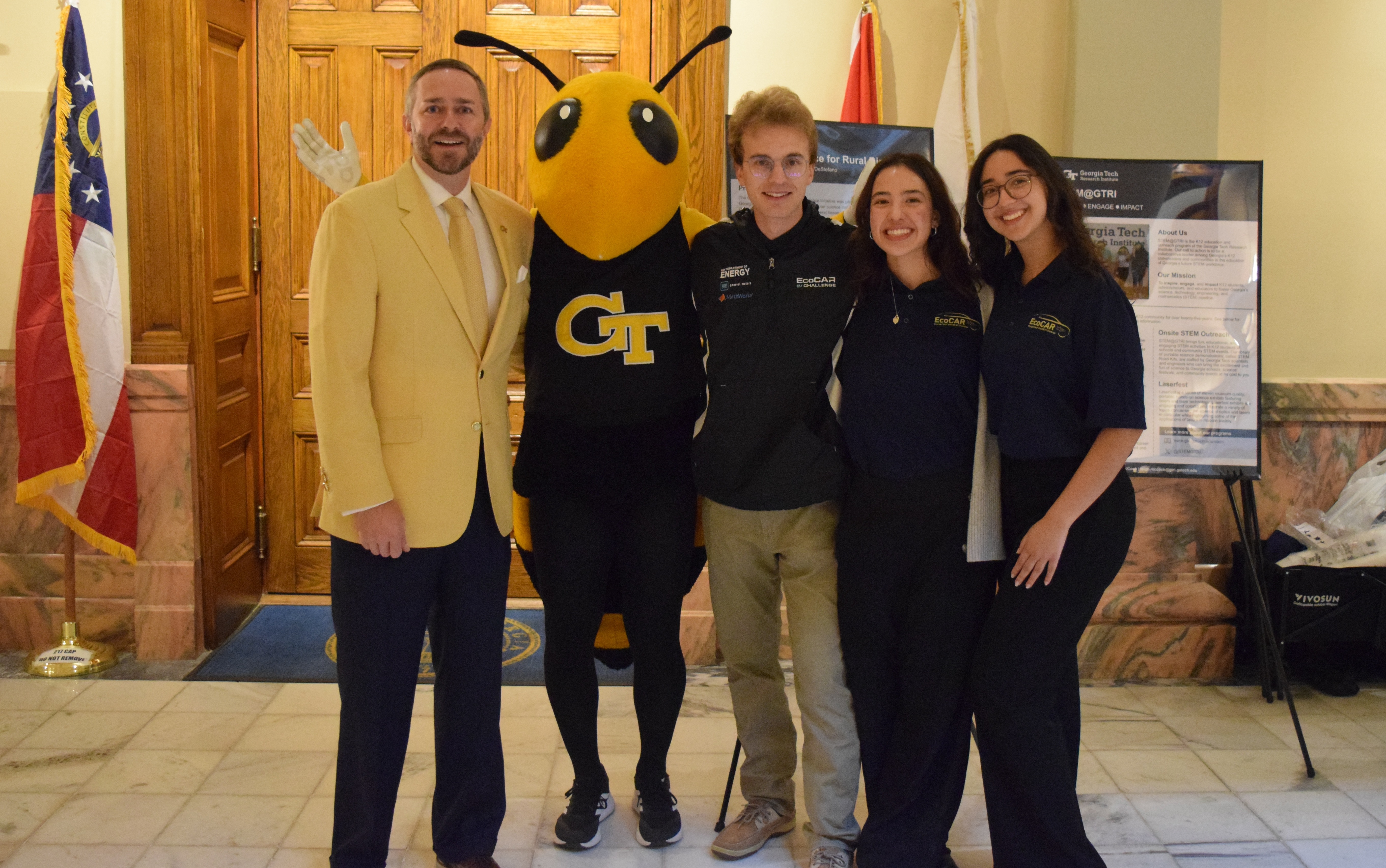 Buzz posing for a photo with four people